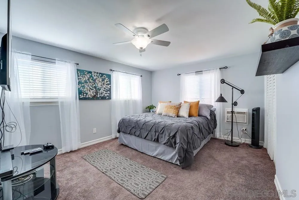 9055 Rosedale Drive Spring Valley, CA 91977 - Photo 20 of 38 a spacious bedroom with a bed and a chandelier