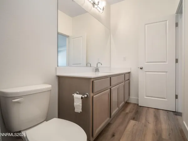a bathroom with a granite countertop toilet sink and mirror
