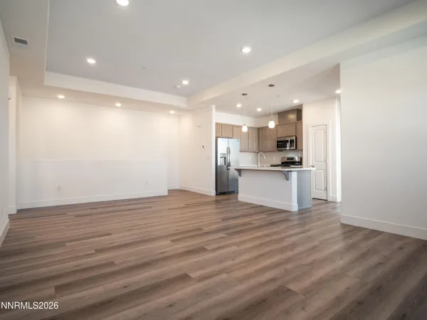 a view of kitchen with kitchen island wooden floor center island and stainless steel appliances