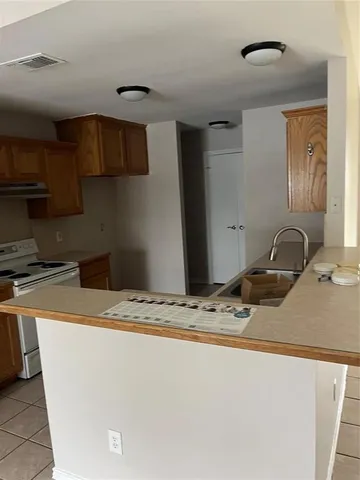 a room with a sink a refrigerator and cabinets
