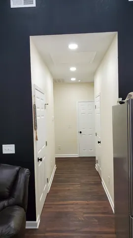 a view of a hallway with wooden floor