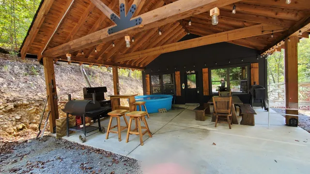 a view of patio with table and chairs a barbeque with wooden floor and fence
