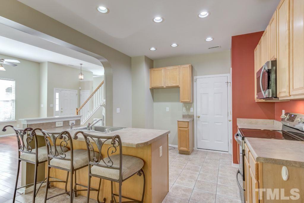 8306 Flat Keystone Drive Raleigh, NC 27613 - Photo 11 of 30 a kitchen with stainless steel appliances granite countertop a sink and a refrigerator