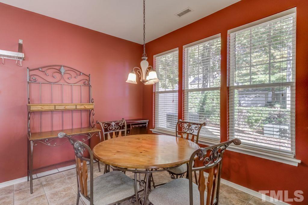 8306 Flat Keystone Drive Raleigh, NC 27613 - Photo 14 of 30 a view of a dining room with furniture window and wooden floor