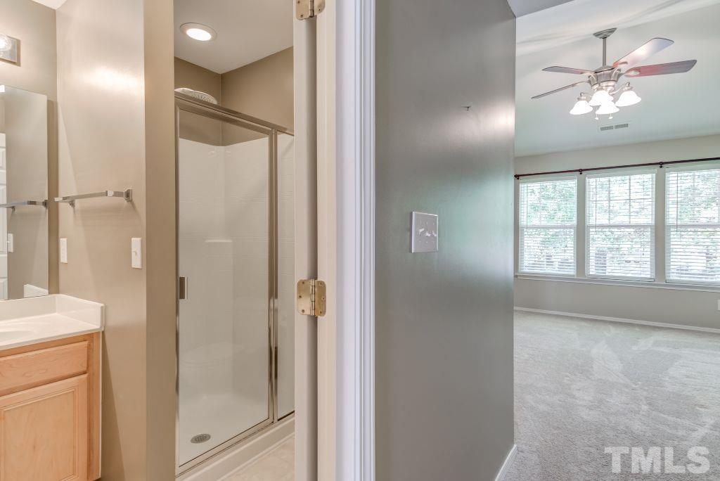 8306 Flat Keystone Drive Raleigh, NC 27613 - Photo 19 of 30 a bathroom with a glass shower door and a window