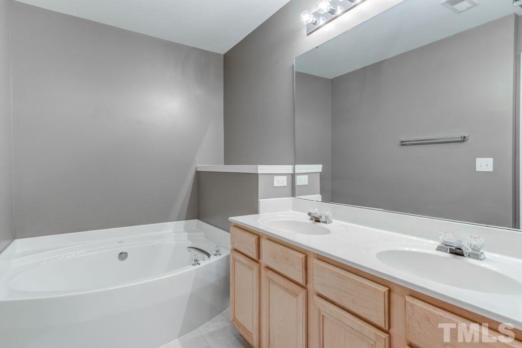 8306 Flat Keystone Drive Raleigh, NC 27613 - Photo 20 of 30 a bathroom with a tub sink and mirror