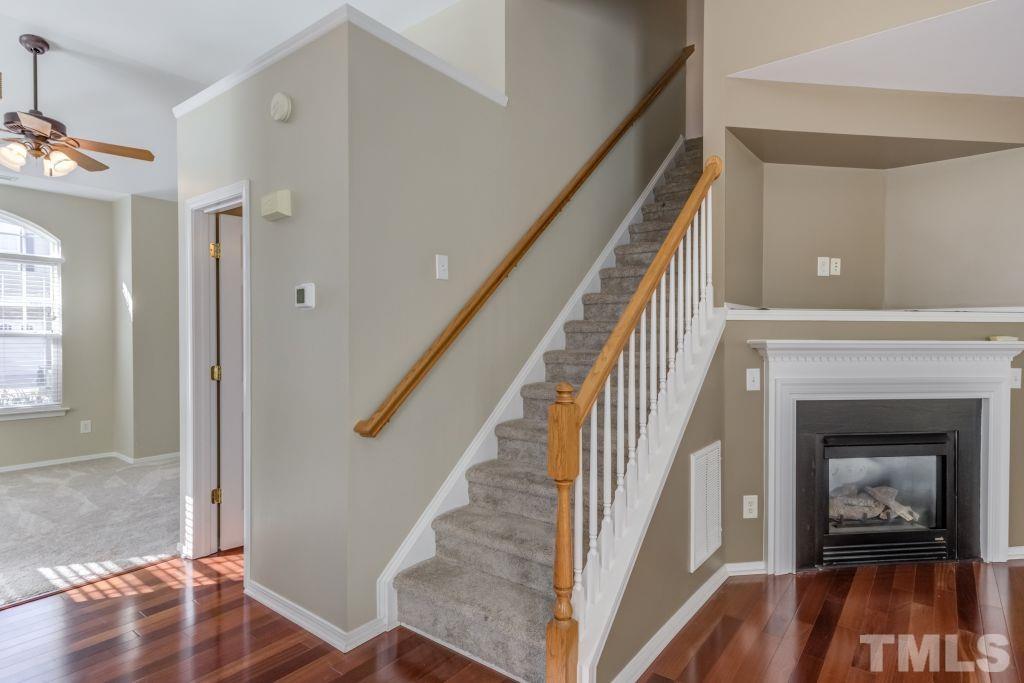 8306 Flat Keystone Drive Raleigh, NC 27613 - Photo 6 of 30 a living room with wooden floor and a fireplace