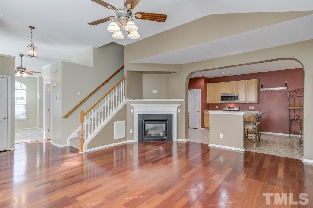 8306 Flat Keystone Drive Raleigh, NC 27613 - Photo 9 of 30 a view of a livingroom with wooden floor and a kitchen space