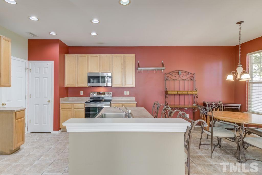 8306 Flat Keystone Drive Raleigh, NC 27613 - Photo 10 of 30 a kitchen with sink a refrigerator and chairs