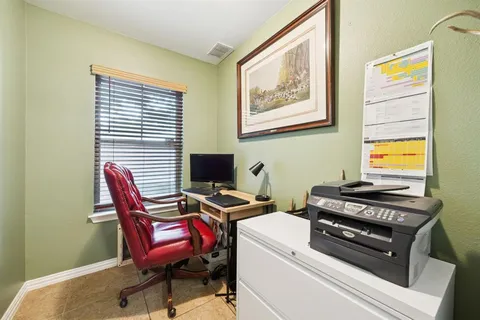 a view of a workspace with furniture and a window