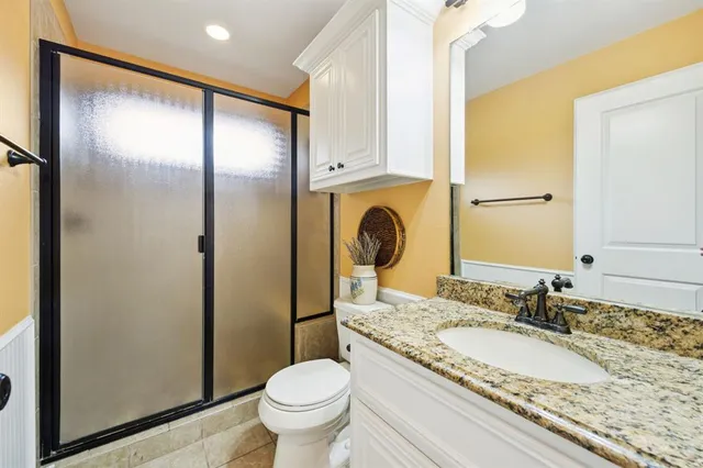 a bathroom with a granite countertop sink toilet and shower