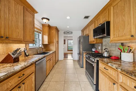 a kitchen with stainless steel appliances granite countertop a sink stove and refrigerator