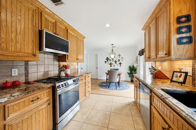 a kitchen with granite countertop a sink stove and cabinets
