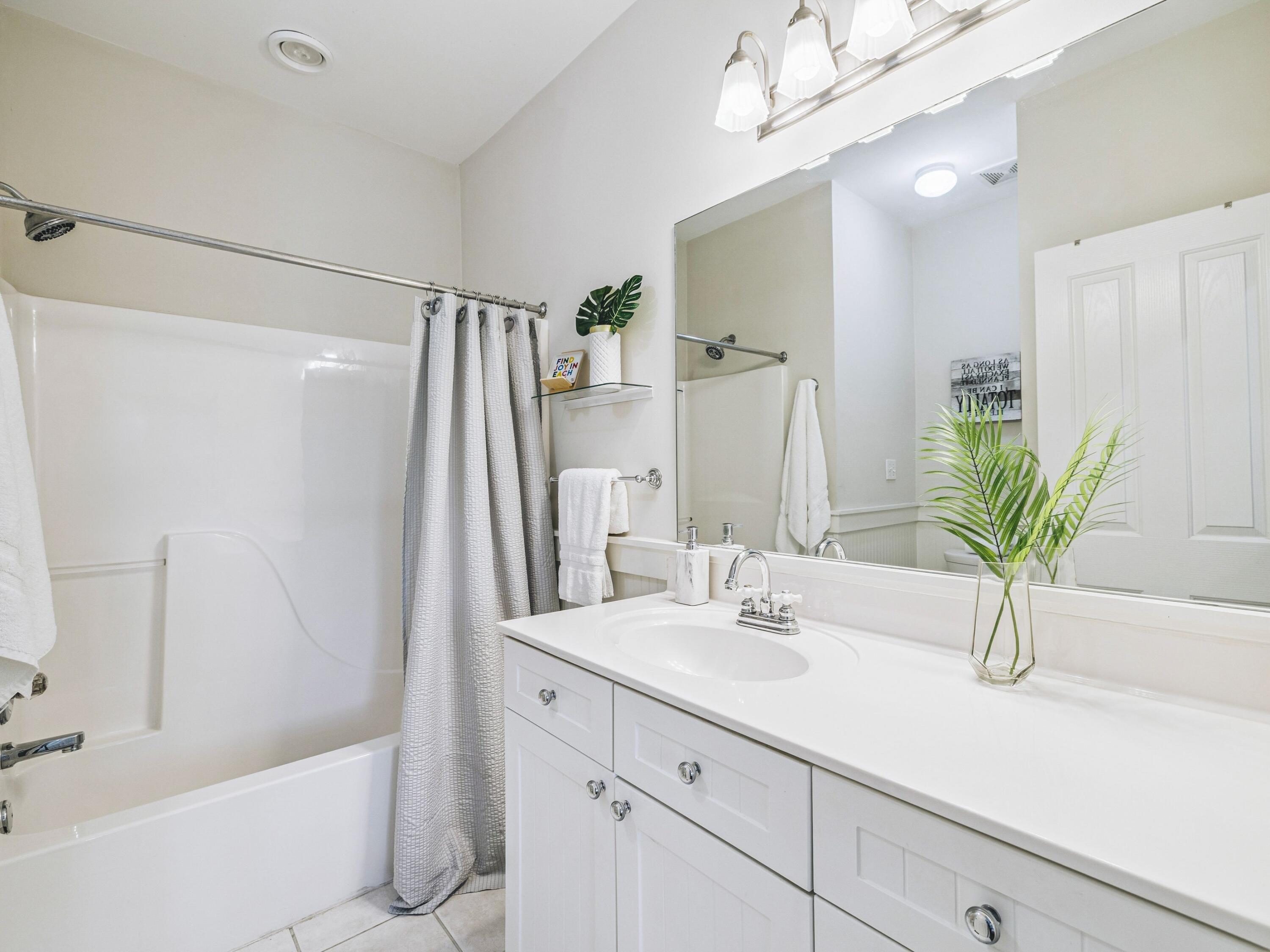 4281 East County Highway 30A, Unit 203 Santa Rosa Beach, FL 32459 - Photo 13 of 35 a bathroom with a sink a large mirror and a shower
