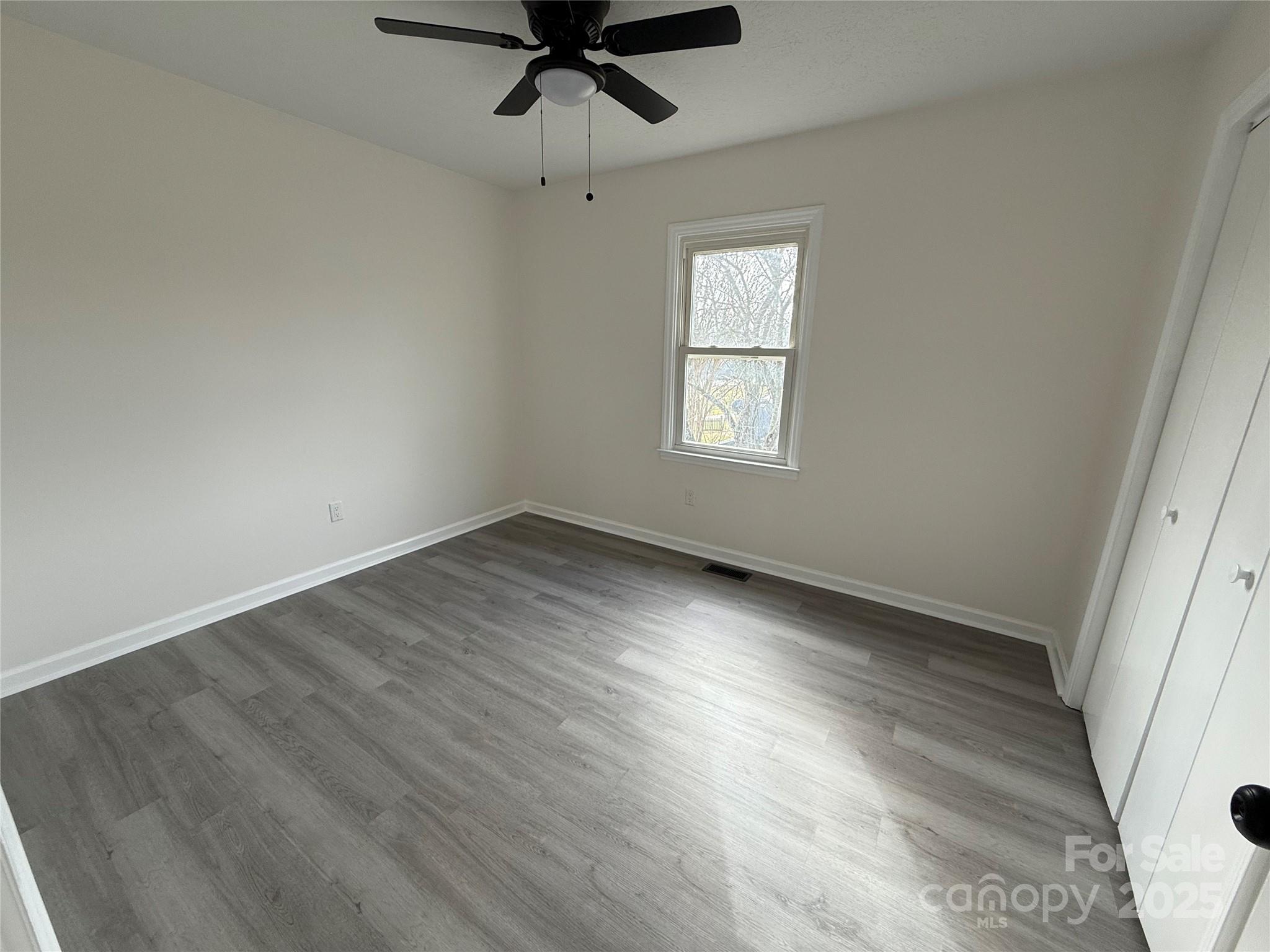 4554 Horseshoe Bend Road Hudson, NC 28638 - Photo 11 of 21 an empty room with wooden floor fan and windows