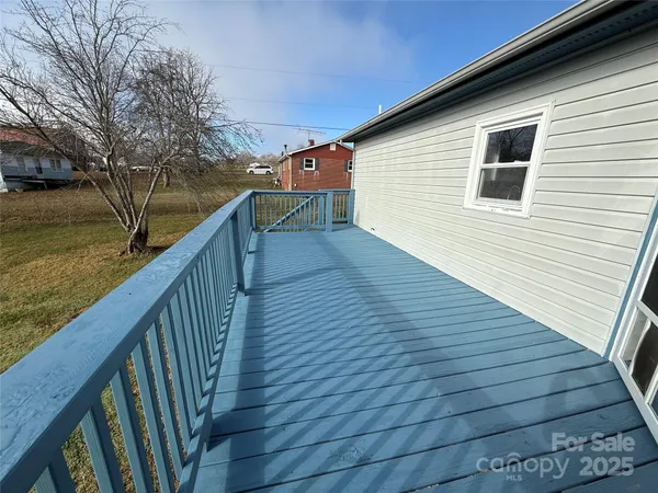 a balcony with wooden floor and trees