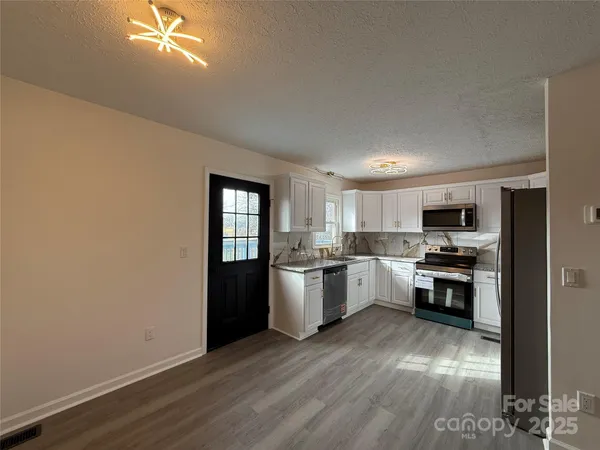 a kitchen with a refrigerator and a stove top oven