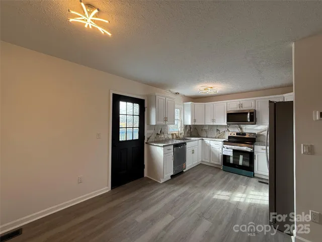 a kitchen with a refrigerator and a stove top oven