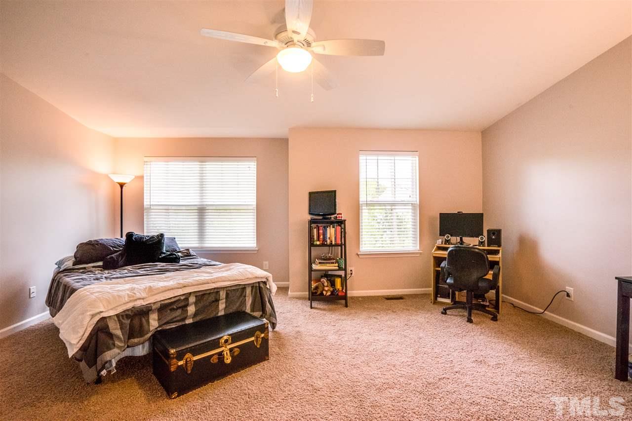 11710 Coppergate Drive, Unit 105 Raleigh, NC 27614 - Photo 16 of 24 a bedroom with a bed and a chandelier