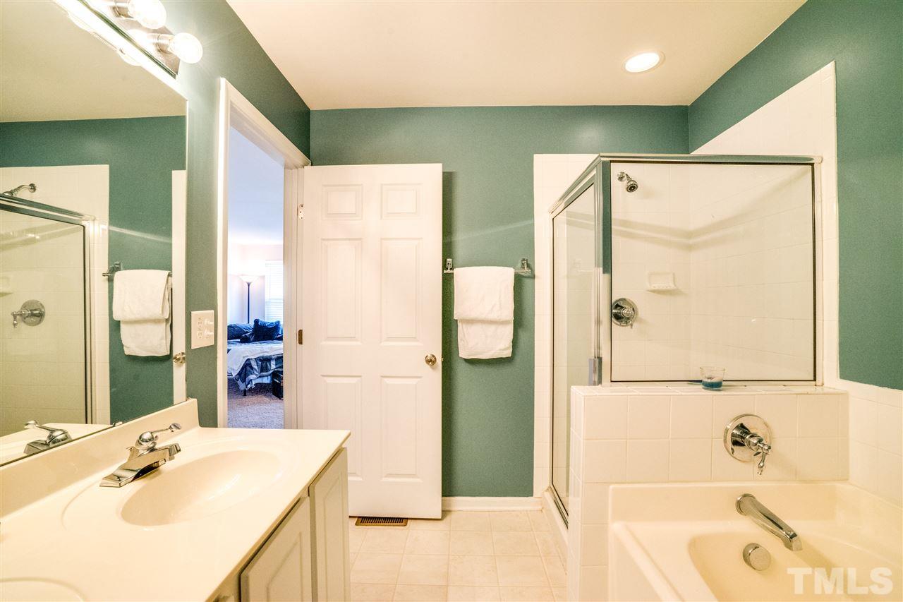 11710 Coppergate Drive, Unit 105 Raleigh, NC 27614 - Photo 20 of 24 a bathroom with a tub sink and mirror