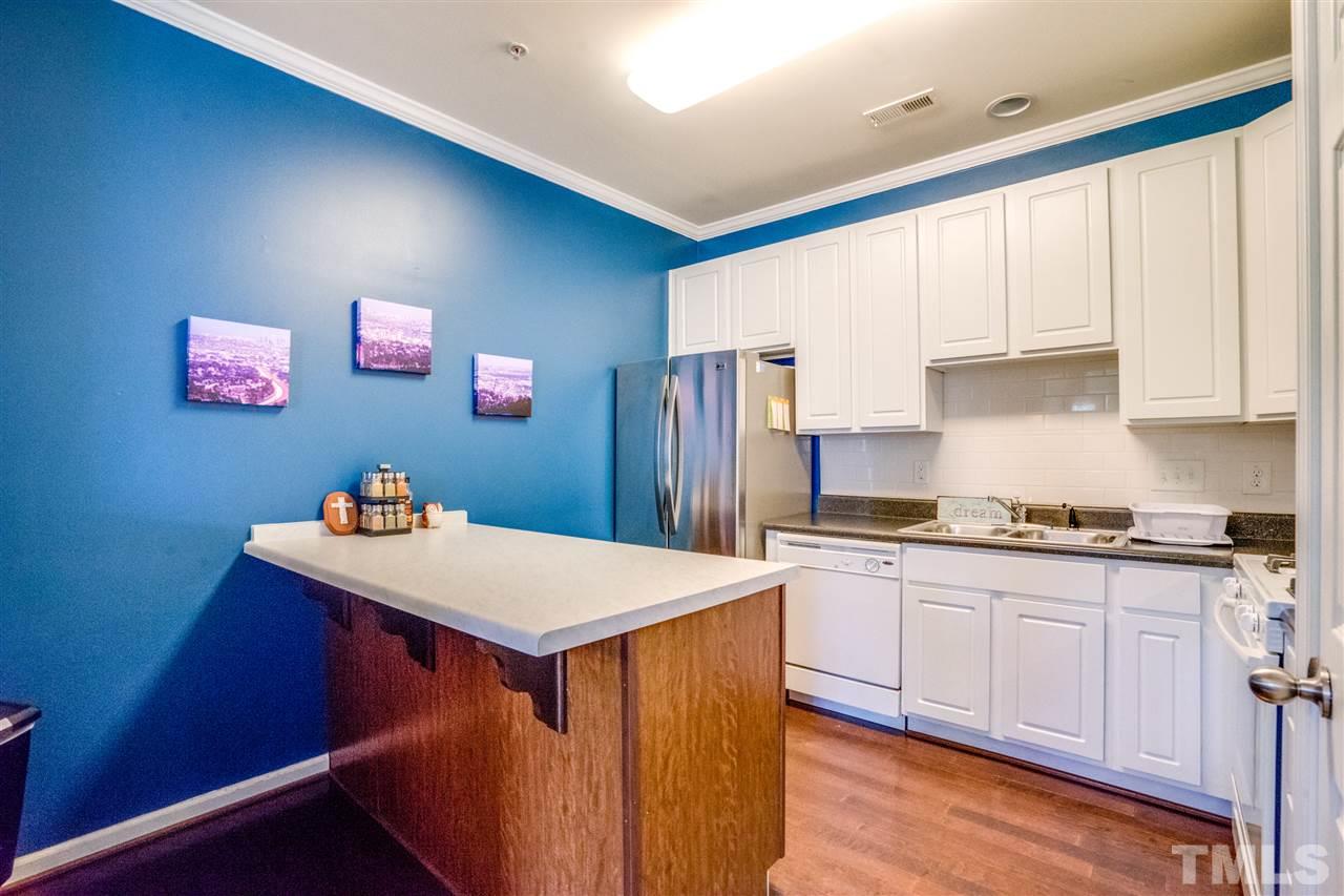 11710 Coppergate Drive, Unit 105 Raleigh, NC 27614 - Photo 8 of 24 a kitchen with stainless steel appliances granite countertop a stove top oven a sink and dishwasher with wooden floor