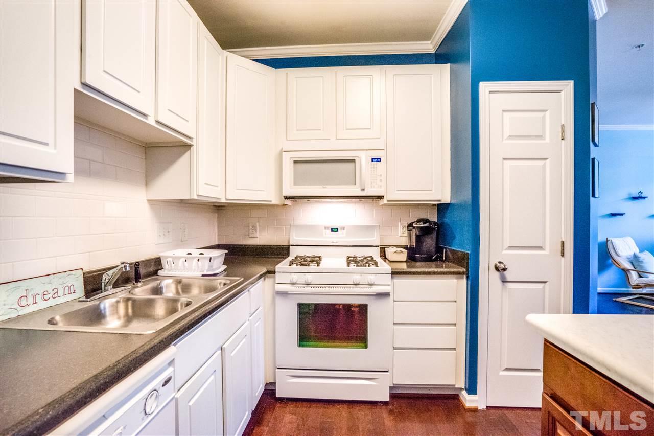 11710 Coppergate Drive, Unit 105 Raleigh, NC 27614 - Photo 9 of 24 a kitchen with a sink stove top oven and cabinets
