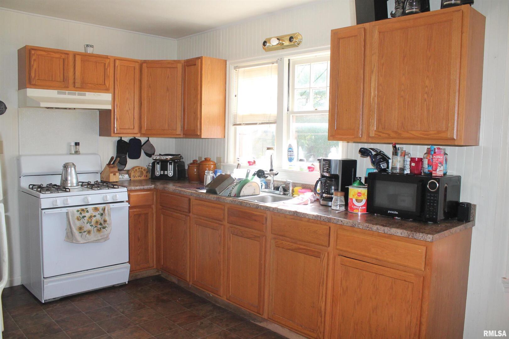 605 West Freeman Street Carbondale, IL 62901 - Photo 5 of 13 a kitchen with stainless steel appliances granite countertop a sink a stove and a refrigerator