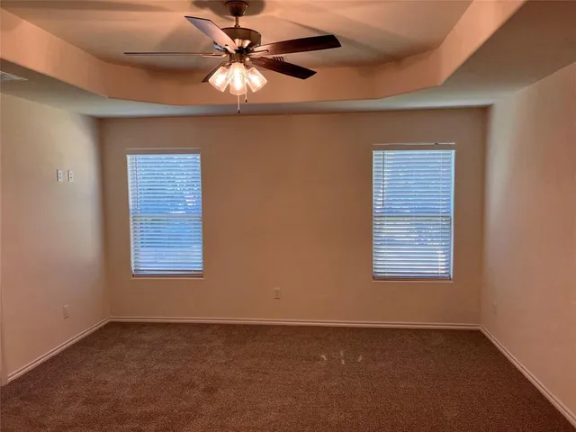 an empty room with a window and a fan