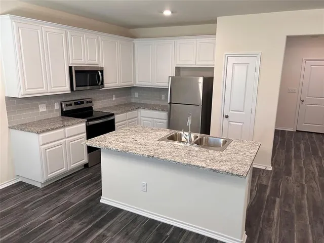 a kitchen with a sink stove and refrigerator