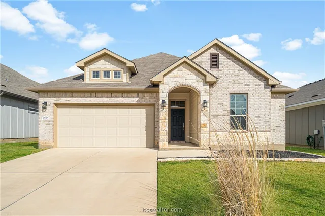 a view of a brick house with a large windows and a yard