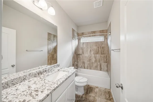 a bathroom with a granite countertop sink toilet and shower