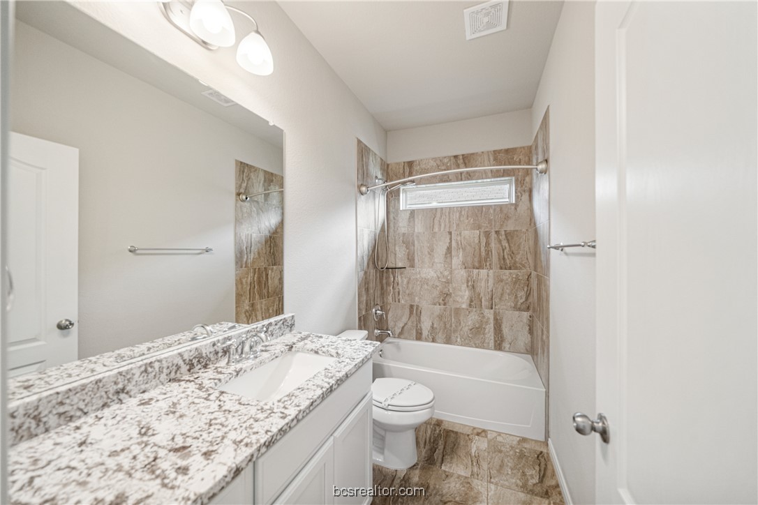 2018 Brisbane Way Bryan, TX 77807 - Photo 12 of 39 a bathroom with a granite countertop sink toilet and shower