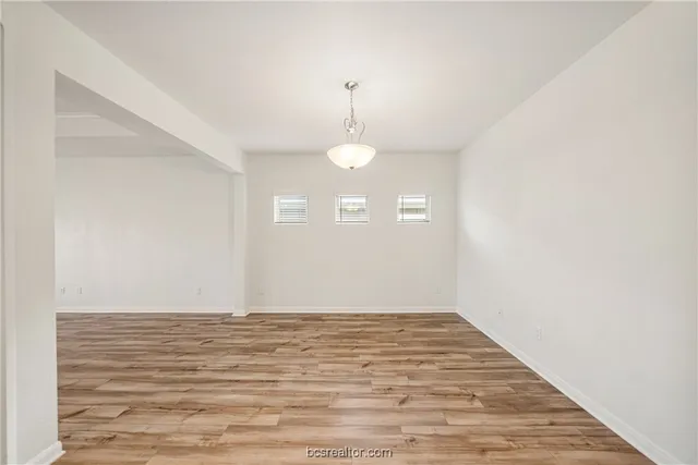 a view of a room with wooden floor and white walls