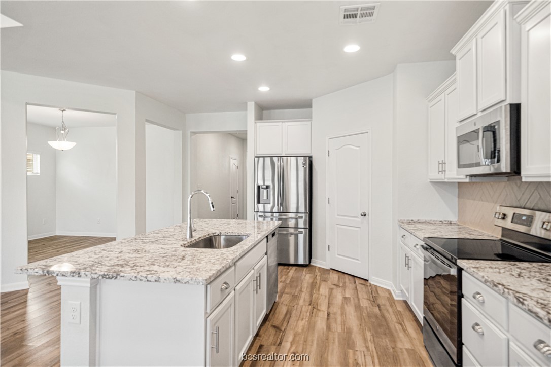 2018 Brisbane Way Bryan, TX 77807 - Photo 25 of 39 a kitchen with stainless steel appliances granite countertop a sink stove and refrigerator