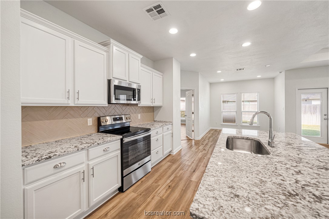 2018 Brisbane Way Bryan, TX 77807 - Photo 27 of 39 a large kitchen with granite countertop a large counter top stainless steel appliances and cabinets