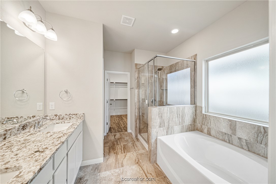 2018 Brisbane Way Bryan, TX 77807 - Photo 31 of 39 a bathroom with a granite countertop tub sink and shower