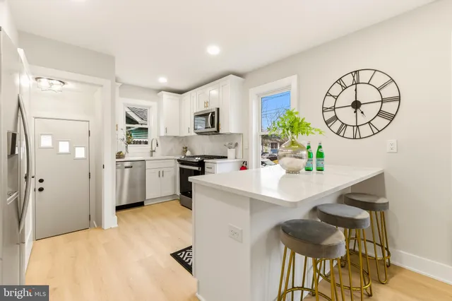 a kitchen with white cabinets and refrigerator