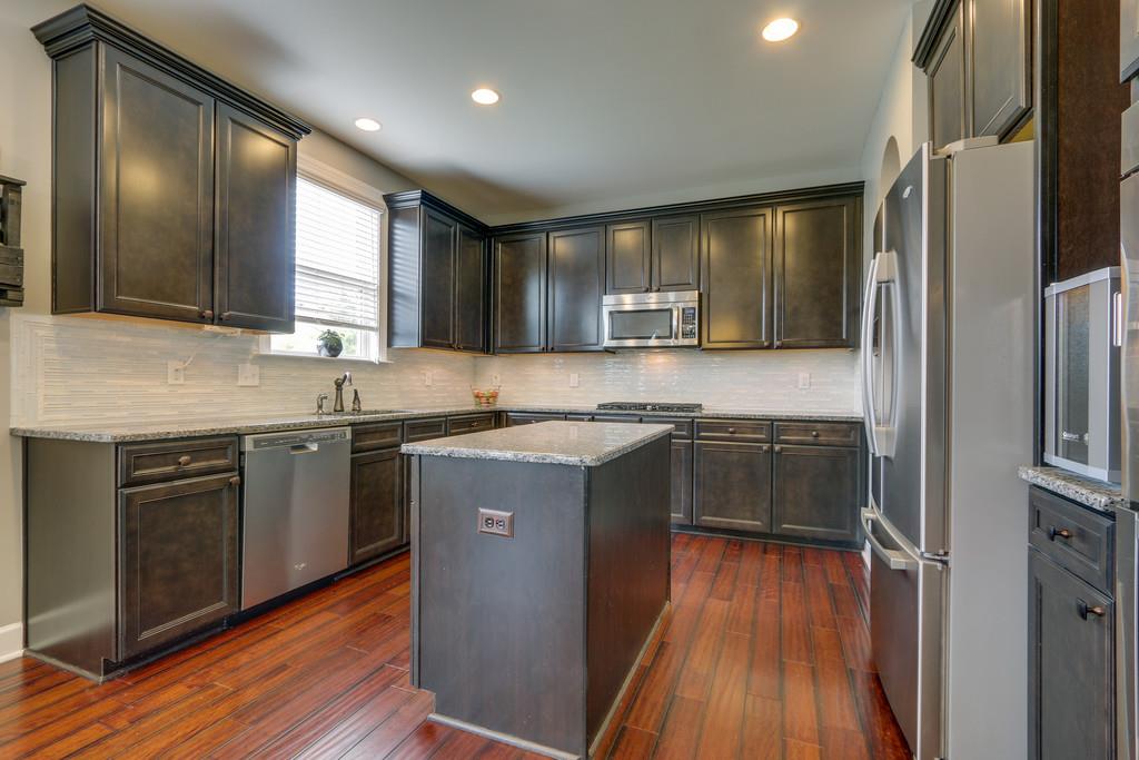 3005 Langston Place Spring Hill, TN 37174 - Photo 14 of 30 a kitchen with stainless steel appliances granite countertop a sink stove and refrigerator