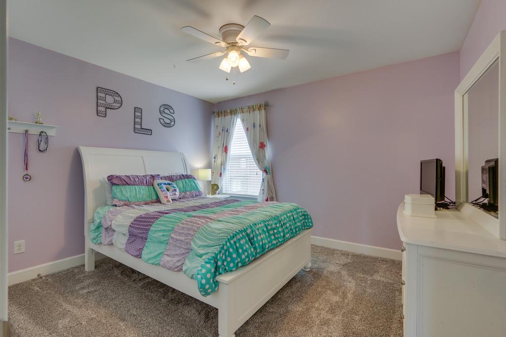 3005 Langston Place Spring Hill, TN 37174 - Photo 23 of 30 a bedroom with a bed chandelier and a window