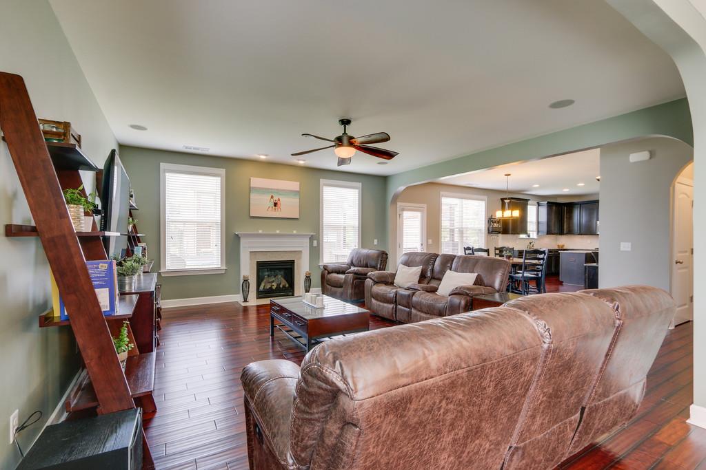 3005 Langston Place Spring Hill, TN 37174 - Photo 9 of 30 a living room with furniture a fireplace and a flat screen tv