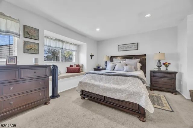 a bedroom with furniture a flat screen tv and a window