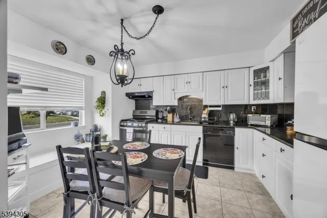 a view of a dining room with furniture a chandelier and wooden floor