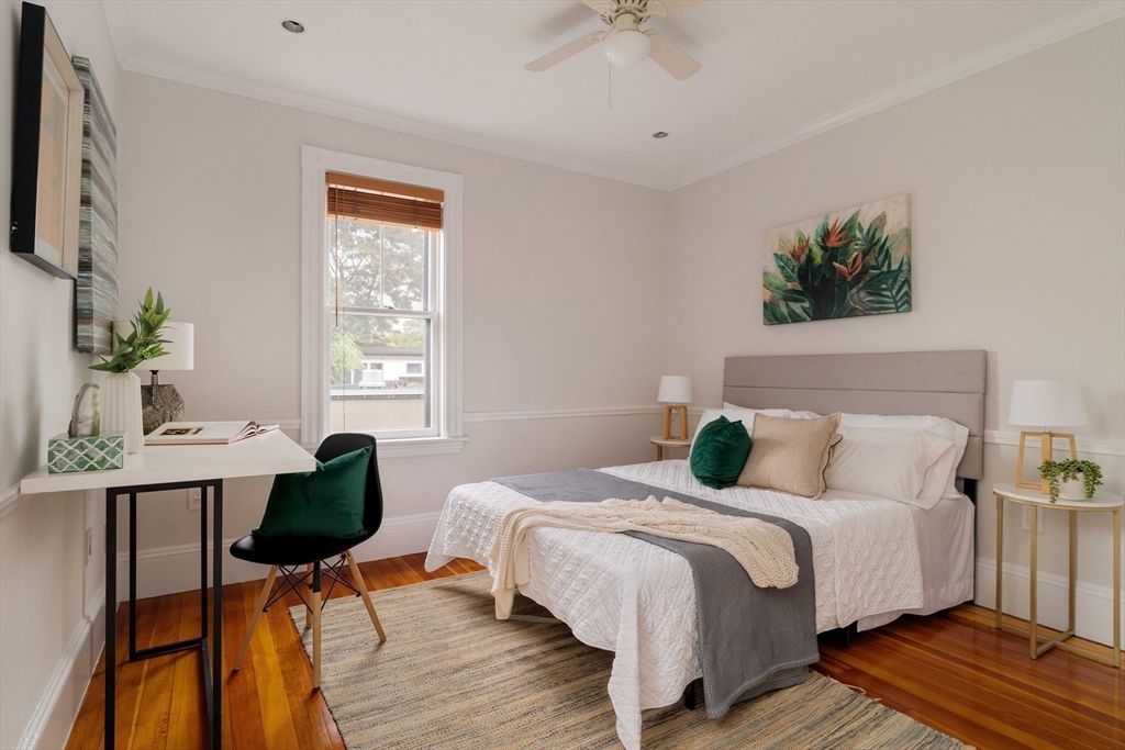 18-20 Windom Street Somerville, MA 02144 - Photo 13 of 34 a bedroom with a bed a table and a potted plant