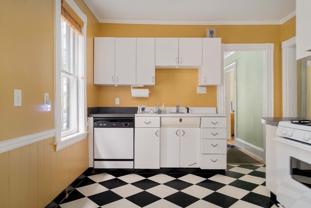 18-20 Windom Street Somerville, MA 02144 - Photo 24 of 34 a kitchen with a checkered floor and white cabinets