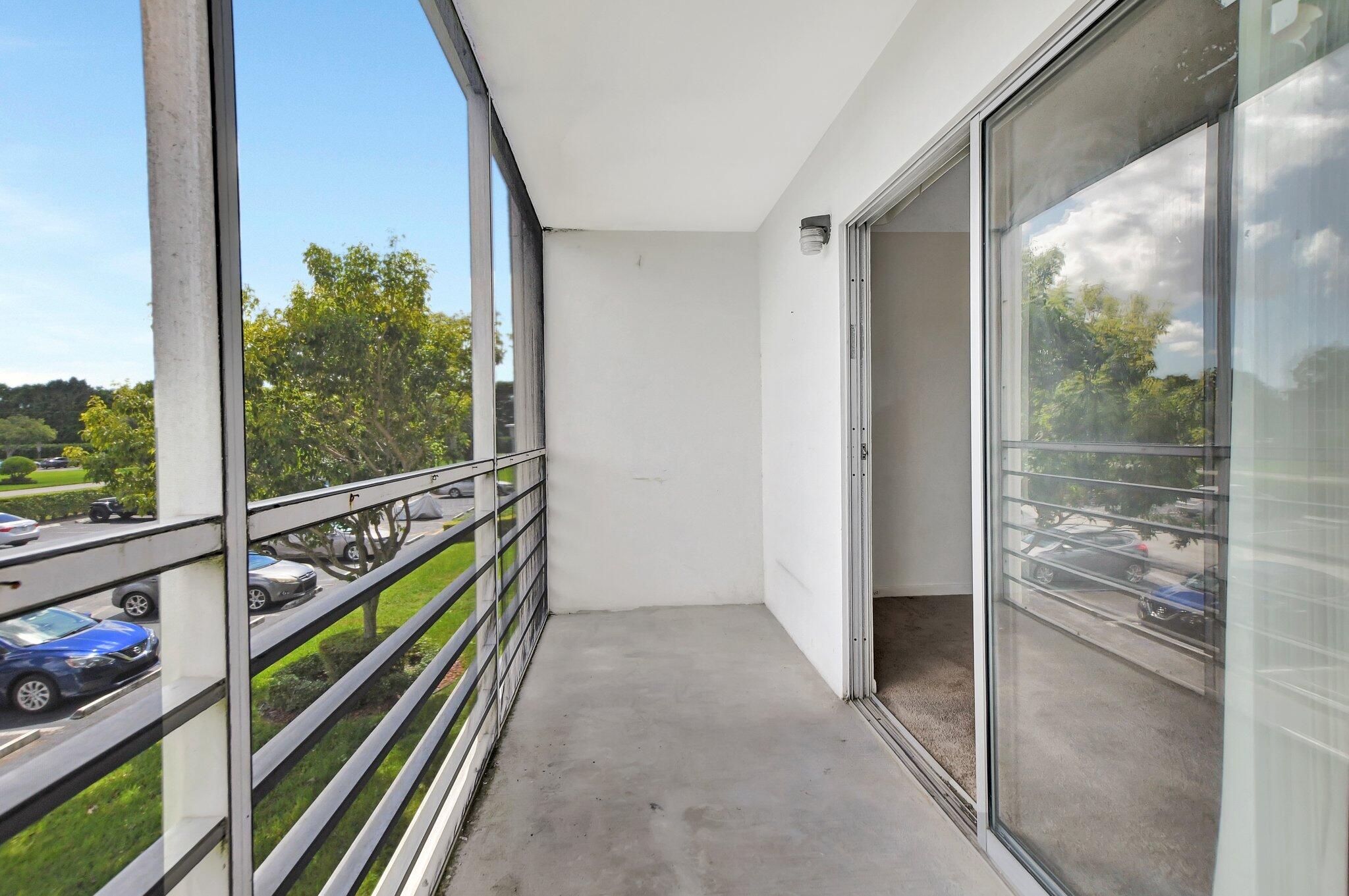 147 Brighton D, Unit D Boca Raton, FL 33434 - Photo 16 of 50 a view of a hallway with wooden floor and stairs