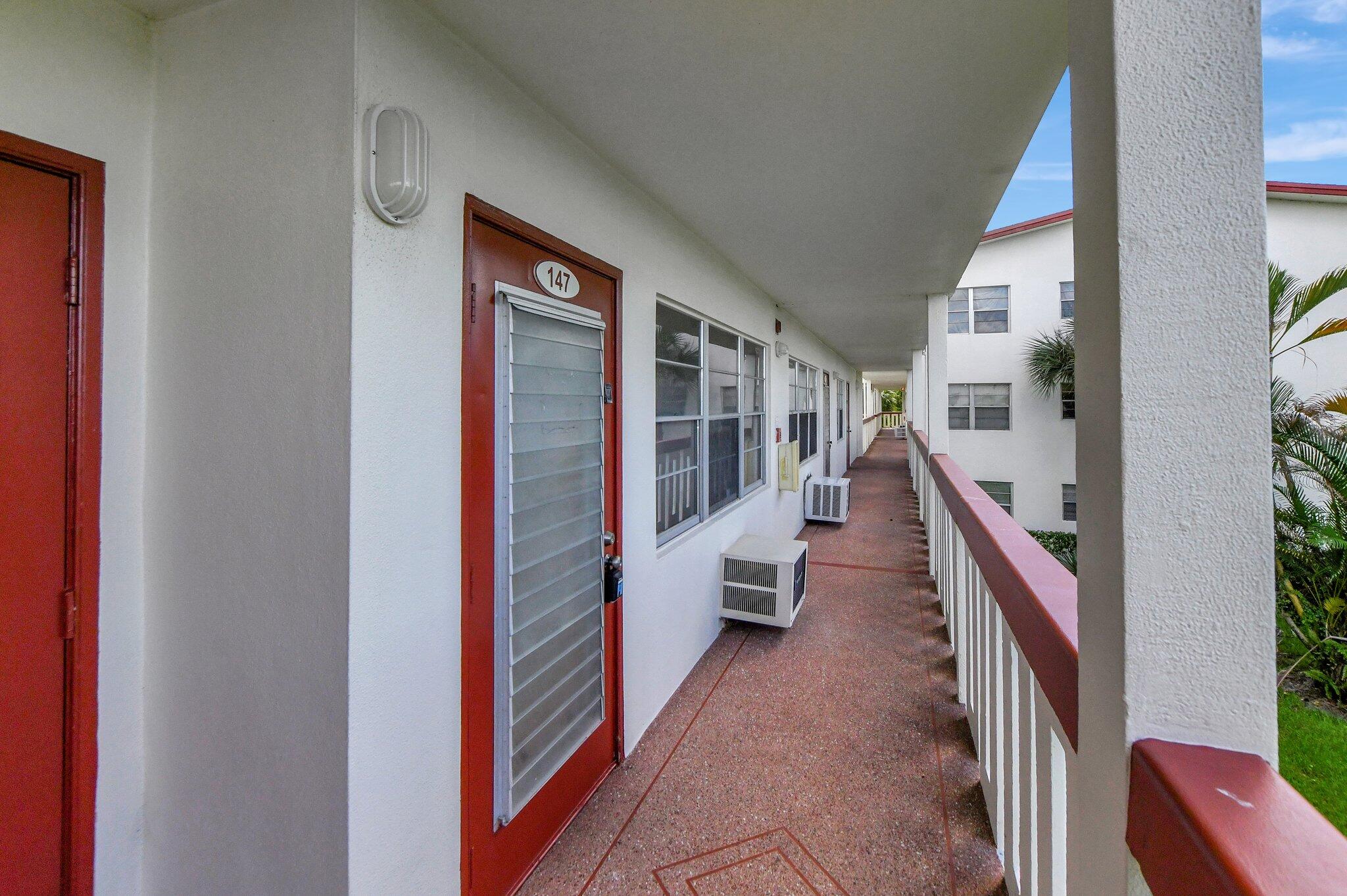 147 Brighton D, Unit D Boca Raton, FL 33434 - Photo 18 of 50 a hallway with wooden floor and staircase