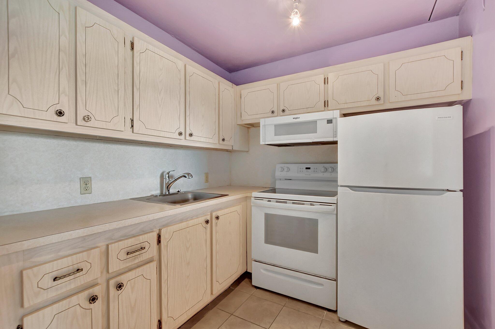 147 Brighton D, Unit D Boca Raton, FL 33434 - Photo 8 of 50 a kitchen with cabinets appliances a sink and a counter space
