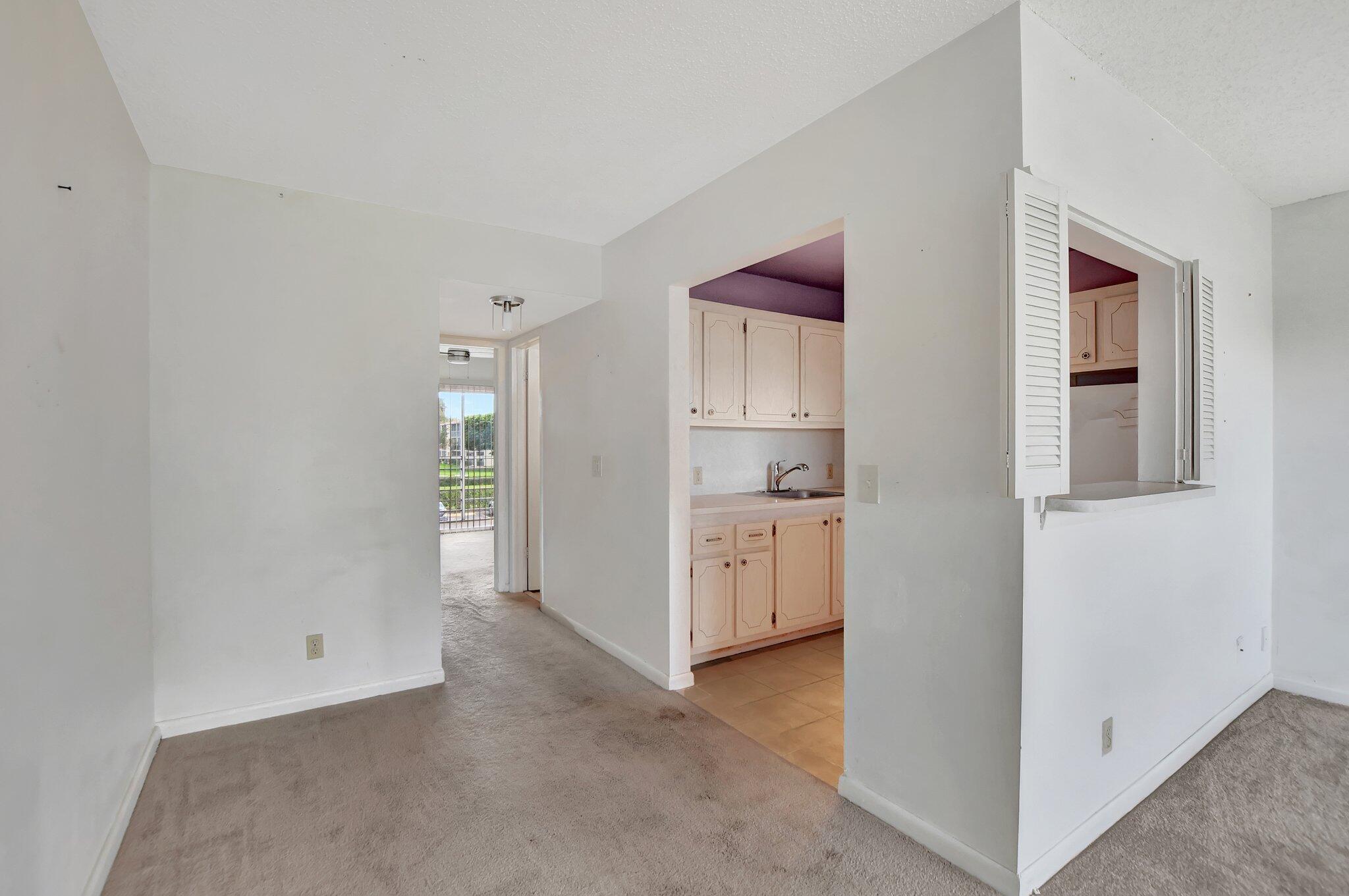 147 Brighton D, Unit D Boca Raton, FL 33434 - Photo 9 of 50 a view of a kitchen with white cabinets