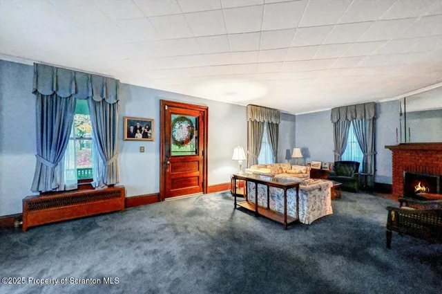 a living room with furniture a flat screen tv and a window
