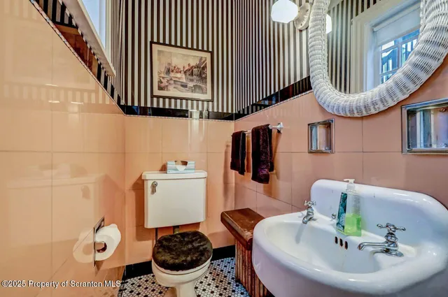 a bathroom with a sink a toilet and a mirror